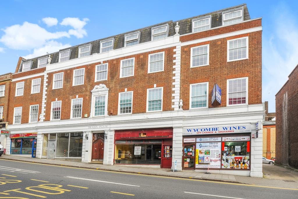 Red brick building with ground-floor shops including Wycombe Wines and white-framed windows.